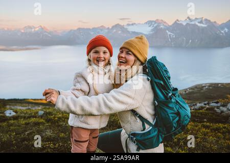 Madre e figlia che ridono divertendosi all'aria aperta famiglia escursioni insieme stile di vita viaggi vacanze attive, donna con zaino che gioca con il bambino i Foto Stock