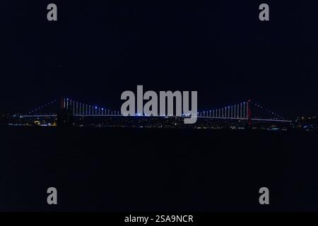 Una vista notturna mozzafiato del Ponte sul Bosforo di Istanbul splendidamente illuminata contro il cielo scuro dalle splendide luci della città Foto Stock