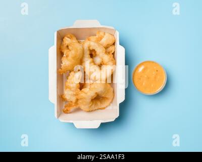 Calamari impanati al forno o anelli di calamari dell'età Kara serviti con salsa agrodolce. Vista dall'alto o disposizione piatta. Isolato su sfondo blu. Delizia croccante, piccante, allettante. Il Karaage Squid perfetto Foto Stock