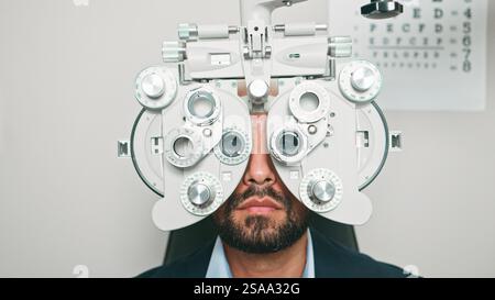 Ritratto di un paziente sottoposto a test di visione con apparecchiatura optometrica Foto Stock
