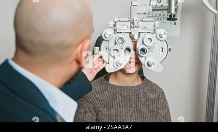 Optometrista che esegue un esame oculare utilizzando apparecchiature avanzate Foto Stock