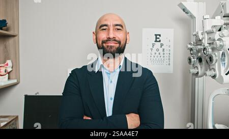 L'optometrista Smiling male posa nel suo ufficio professionale Foto Stock