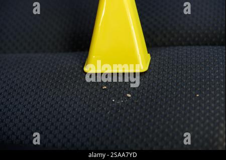 Pulizia di un seggiolino per auto all'interno con un aspirapolvere portatile, pulizia dei tessuti del seggiolino per auto da sporco e polvere, primi piani. Abitacolo pulito Foto Stock