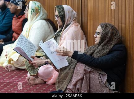 Durante una messa mattutina i sacerdoti sikh leggono l'intera bibbia mentre i fedeli leggono. In un tempio nel Queens, New York. Foto Stock