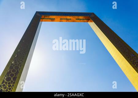 Dubai, Emirati Arabi Uniti - 9 dicembre 2024: Cornice fotografica di Dubai. Cornice dorata più grande per le foto. Persone che camminano davanti a un monumento architettonico e all'alta piattaforma di osservazione nel parco Zabeel. Foto Stock
