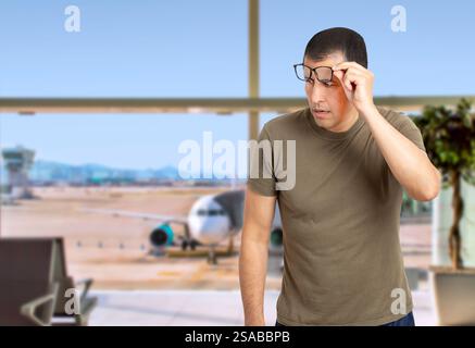 In vita ritratto dell'uomo con gli occhiali che li portano fuori per guardare lo spazio vuoto da parte all'aeroporto Foto Stock