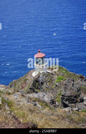 Faro panoramico di Makapu'u su un'aspra scogliera, Oahu, Hawaii, storico punto di riferimento costiero che si affaccia sul profondo blu dell'Oceano Pacifico. Foto Stock