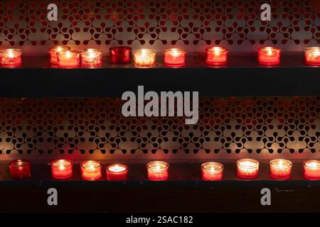 Candele votive o di preghiera accese in una chiesa, tradizione cristiana. Foto Stock