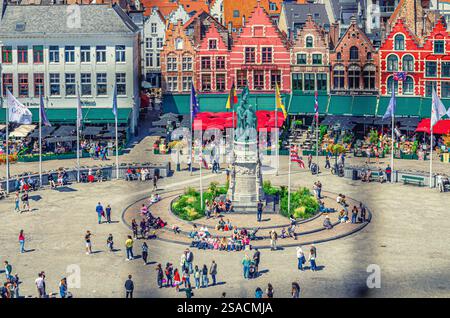 Bruges, Belgio, 5 luglio 2023: Veduta aerea della piazza del mercato con turisti, colorate case cittadine in stile fiammingo-barocco vecchie case medievali a Bru Foto Stock