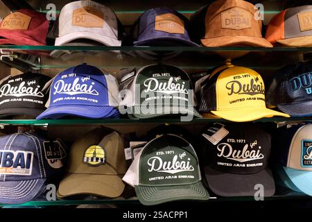 Negozio di souvenir nel souk di Deira. Cappellini con logo Dubai. Dubai, EAU, Emirati Arabi Uniti. Foto Stock
