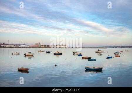 I relitti arrugginiti si arenano nella baia di Santander Cantabria, in Spagna, con piccole barche da pesca e yacht a motore ormeggiati alle boe nel pomeriggio invernale Foto Stock