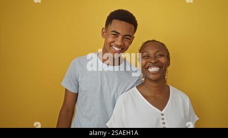 Madre e figlio condividono un sorriso amorevole su un vibrante sfondo giallo, evidenziando il legame familiare e la felicità. Foto Stock