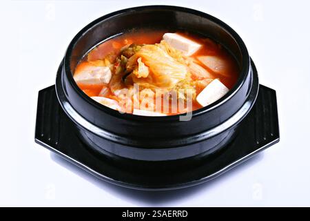 Kimchi jjjigae (Kimchi Stew) zuppa coreana calda e piccante su sfondo bianco Foto Stock