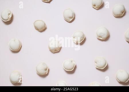 Stesa piatta di gnocchi congelati disposti su una superficie neutra. Foto Stock