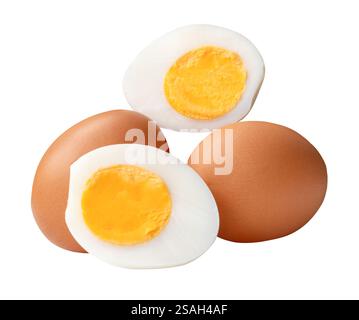 La vista laterale di due uova di pollo crude e dell'uovo sbucciato o bollito con tuorlo d'uovo in due metà in pila è isolata su sfondo bianco con percorso Foto Stock