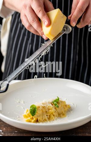 Deliziosa pappardelle di pasta italiana con parmigiano in porcellana bianca su un tavolo di legno Foto Stock