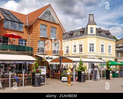 Persone sulla terrazza esterna del caffè lungo la passeggiata Am Hafen, la città vecchia di Kappeln, Schleswig-Holstein, Germania Foto Stock