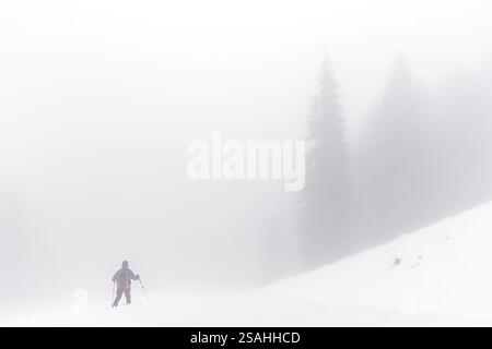Escursionista avvolto da nebbie in montagna, Val Brembana, Lombardia, Italia Foto Stock