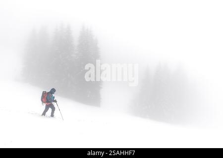 Escursionista avvolto da nebbie in montagna, Val Brembana, Lombardia, Italia Foto Stock