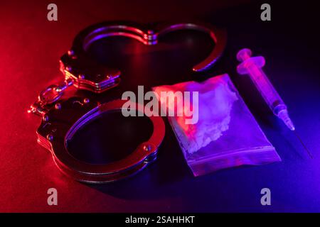 Traffico e traffico di droga, manette e sacchetti di cocaina su sfondo nero. Affari con sostanze illegali e arresti Foto Stock