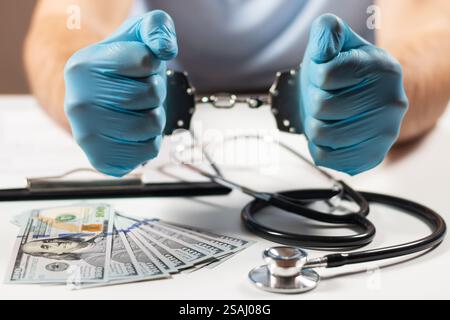 Un medico con banconote in dollari e manette. concetto di corruzione medica, corruzione, crimine. Foto Stock