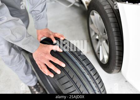 La sostituzione di un pneumatico in una riparazione auto shop - lavoratore assembla i cerchioni del veicolo Foto Stock