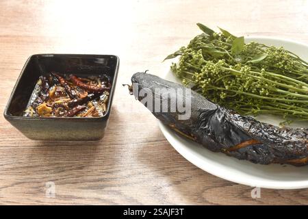 Pesce gatto alla griglia e verdure indiane dell'albero siamese sul piatto, con salsa di pesce agrodolce Foto Stock