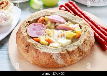 La zuppa di segale acida all'interno della pagnotta di pane. Tavolo per la colazione di Pasqua. Foto Stock