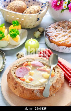La zuppa di segale acida all'interno della pagnotta di pane. Tavolo per la colazione di Pasqua. Foto Stock