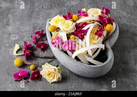 Composizione floreale con rose e orchidee a forma di cuore. Decorazioni per feste Foto Stock