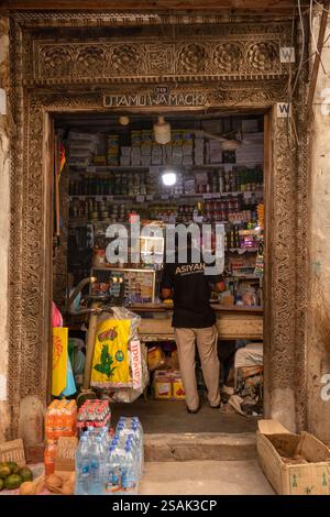 Africa Tanzania, Zanzibar, Stonetown, città vecchia, Jamatini Road, piccolo negozio locale all'interno della vecchia porta di legno Foto Stock