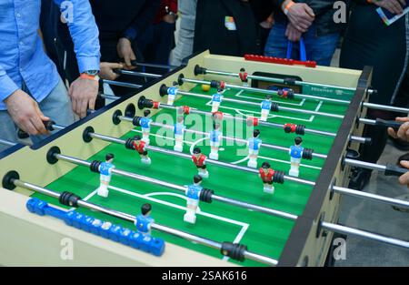 Uomini mani che giocano a calcio al tavolo da calcio, gruppo di persone che guardano. Foto Stock