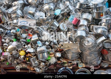 Un'enorme pila di utensili da cucina, pentole, padelle e accessori, impilati a caso uno sull'altro per consentire ai clienti di scegliere. Foto Stock