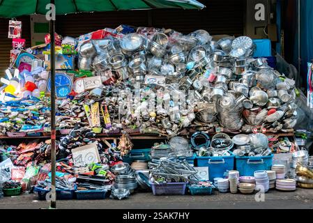 Un'enorme pila di utensili da cucina, pentole, padelle e accessori, impilati a caso uno sull'altro per consentire ai clienti di scegliere. Foto Stock