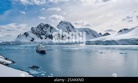 MS Fram, una nave da crociera HX Expedition, ancorata nel porto di Orne in Antartide. Circondato da acque blu glaciali e montagne innevate Foto Stock