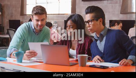 Tre designer in Creative Business che utilizzano laptop Meeting in un moderno ufficio multiculturale Foto Stock