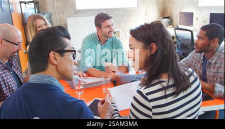 Gruppo multiculturale di imprenditori creativi che si incontrano intorno al tavolo nell'ufficio moderno Foto Stock
