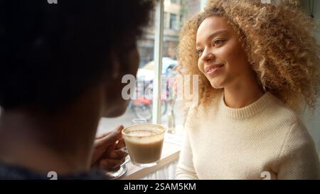 Primo piano della riunione di coppia al City Cafe gustando caffè e torta insieme Foto Stock