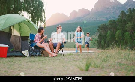 Gita in campeggio con la famiglia in campagna sul lago rilassante mentre i bambini giocano con le reti da pesca Foto Stock