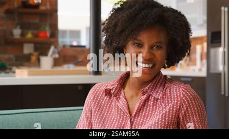 Ritratto di sorridente ragazza rilassante sul divano di casa Foto Stock
