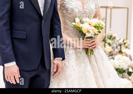 Un uomo e una donna sono vicini l'uno all'altro. L'uomo indossa un vestito blu e la donna indossa un vestito bianco Foto Stock