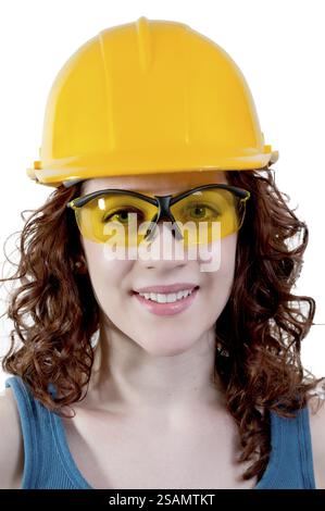 Lavoratrice edile che indossa un elmetto e occhiali di sicurezza Foto Stock