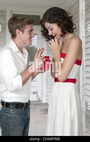 Il marito o fidanzato dando un presente o il dono di sua moglie o ragazza Foto Stock