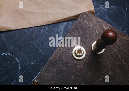 Vista dall'alto di un set di guarnizioni a cera con manico in legno su una superficie blu testurizzata con busta Foto Stock