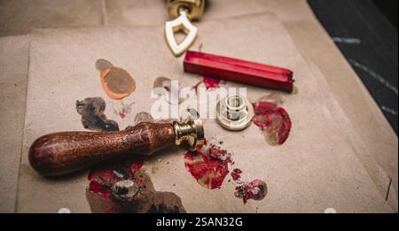 Set di guarnizioni vintage in cera con bastoncino di cera rosso su carta marrone, per creare un'atmosfera artistica Foto Stock