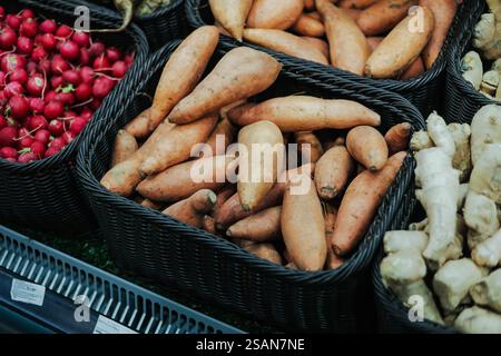 Patate dolci fresche nel cestino su uno scaffale del supermercato. Primo piano. Foto Stock