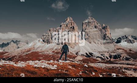 Tra la maestosità mozzafiato delle Dolomiti, un uomo aspro e intrepido si erge a soggezione della grandezza della natura. Foto Stock