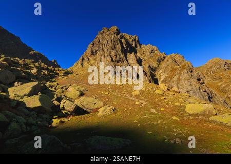 Un'alba chiara lungo il sentiero per il lago Tobavarchkhili (Toba) a Samegrelo, Georgia. I picchi del grande Caucaso sorgono nella catena degli Egrisi sotto il cielo blu. Foto Stock