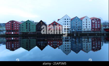 I colorati edifici sul lungomare si riflettono in acque calme al crepuscolo in una posizione tranquilla. Trondheim Foto Stock
