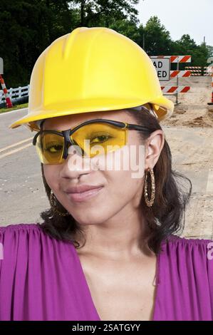 Una donna afroamericana di colore operaia che indossa un elmetto e occhiali di sicurezza Foto Stock